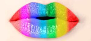 A close up of a woman 's lips with rainbow lipstick.