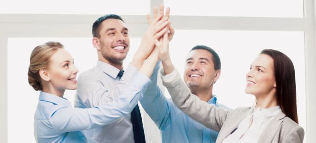 A group of business people are giving each other a high five.