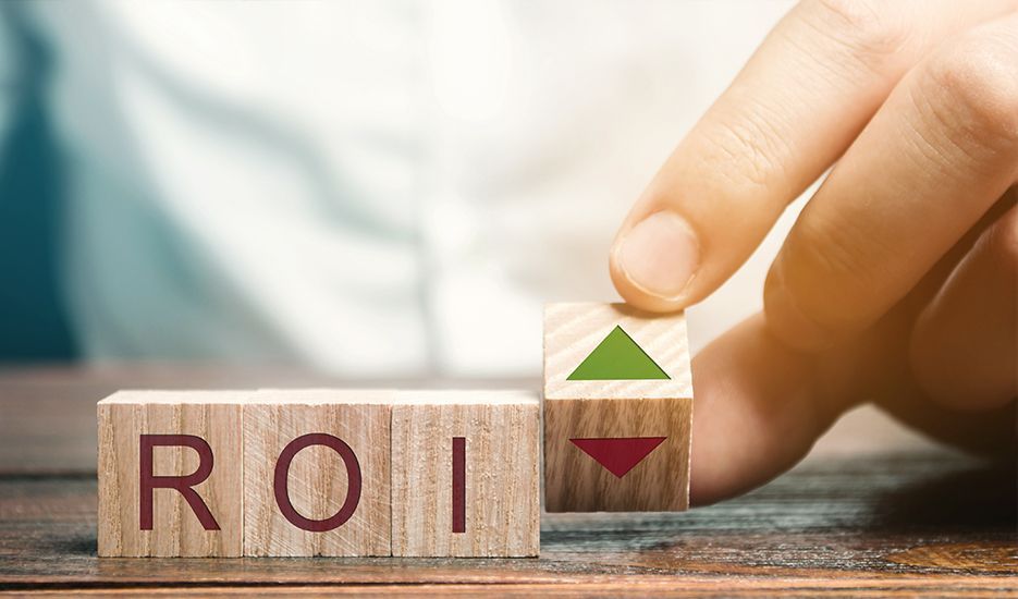 A person is holding a wooden block with the word roi written on it.
