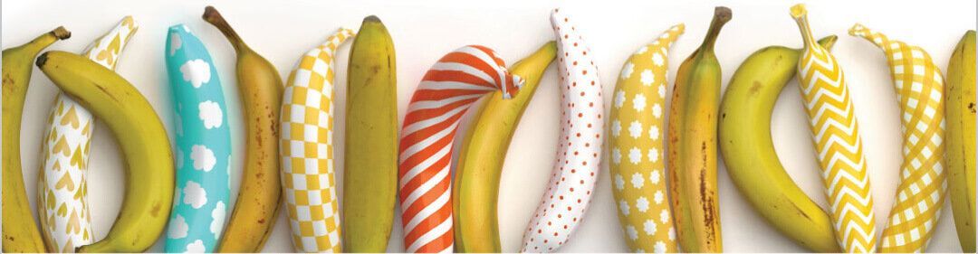 A bunch of bananas with different patterns on them are lined up in a row.