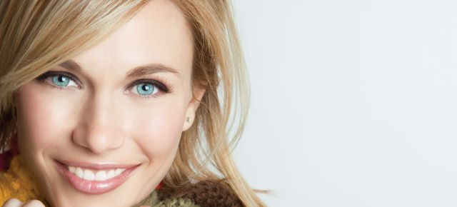 A close up of a woman 's face with a scarf around her neck.