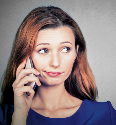 A woman in a blue dress is talking on a cell phone