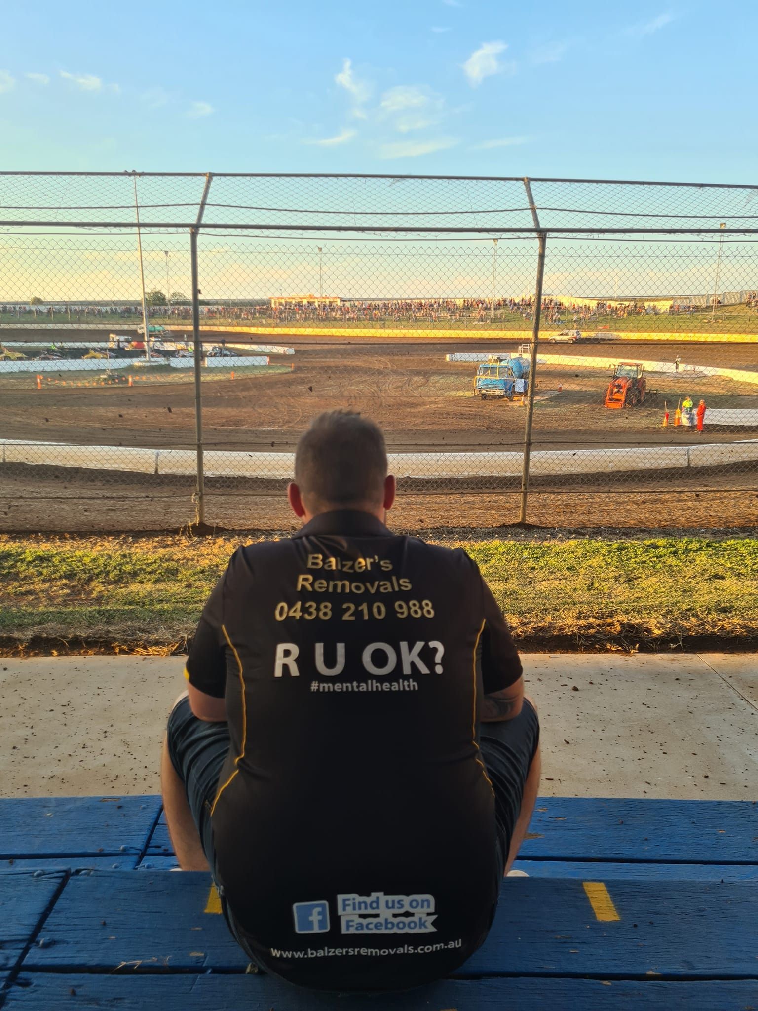 A Man Is Sitting On A Bench Looking At A Race Track — Balzers Removals and Carrying in Helidon, QLD