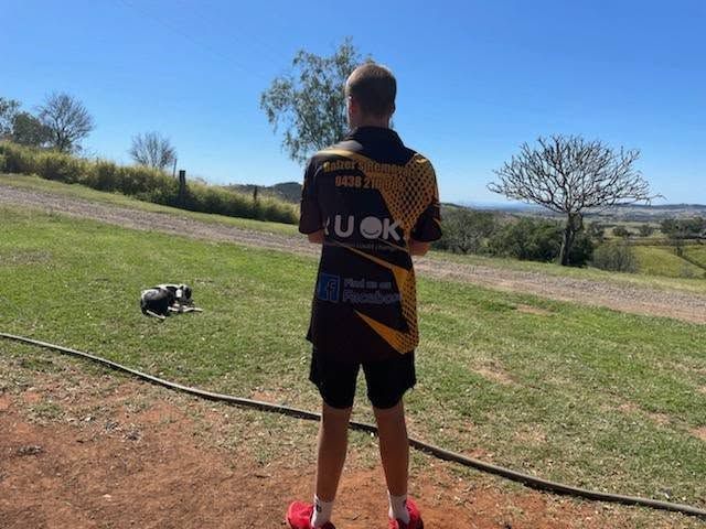 A Man Wearing A Shirt That Says U Ok Is Standing In A Field With A Dog — Balzers Removals and Carrying in Helidon, QLD