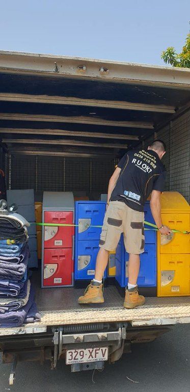 A Man Is Loading Boxes Into The Back Of A Truck — Balzers Removals and Carrying in Helidon, QLD