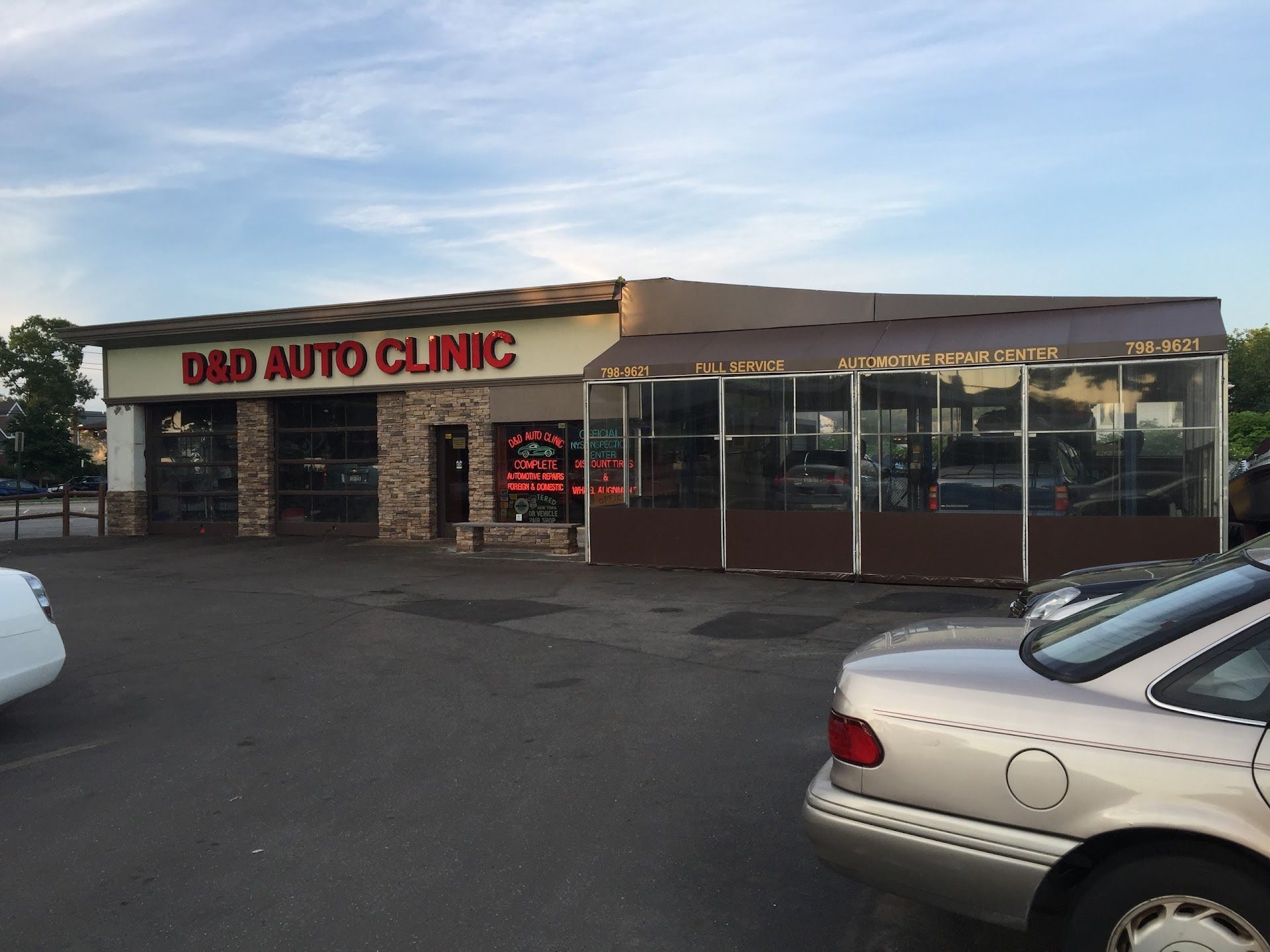 D&D Auto Clinic exterior with cars parked in front. Brick and glass storefront under a brown awning. | D & D Auto Clinic