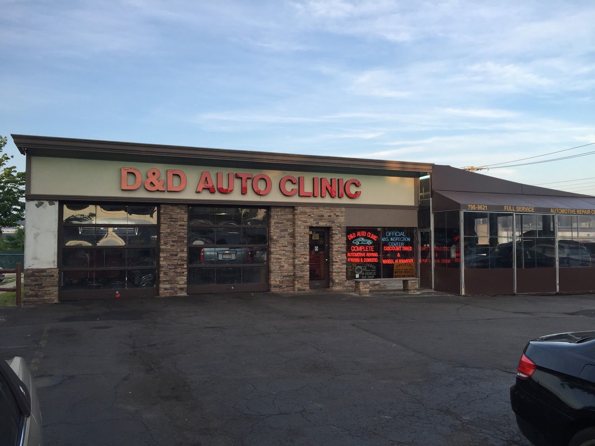 D&D Auto Clinic: exterior view of auto repair shop with brick facade and large windows, under a blue sky.| D & D Auto Clinic
