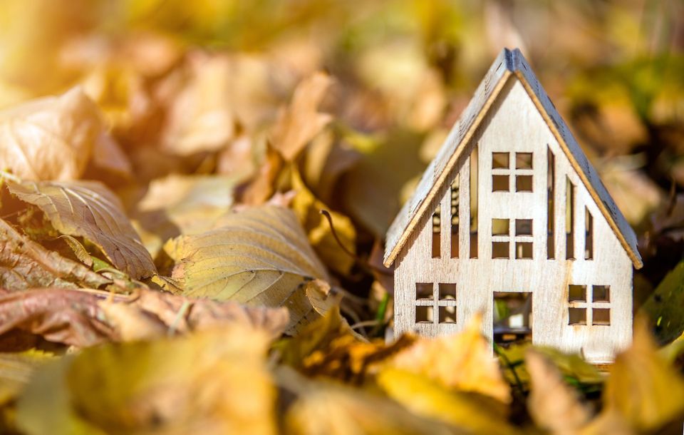 modellino di casa su foglie autunnali