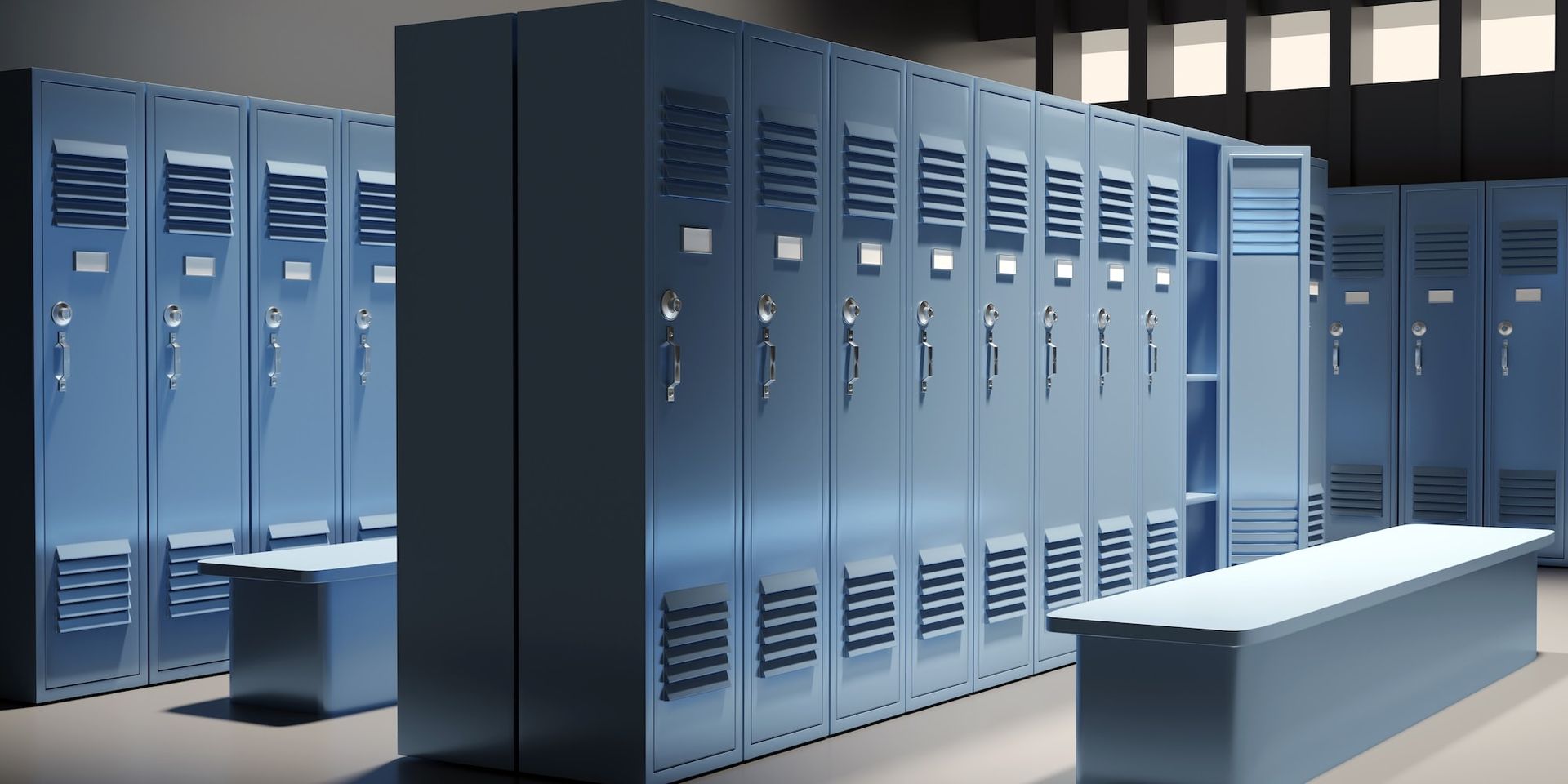 Reihen blauer Metallspinde in einem Umkleideraum, davor Bänke.