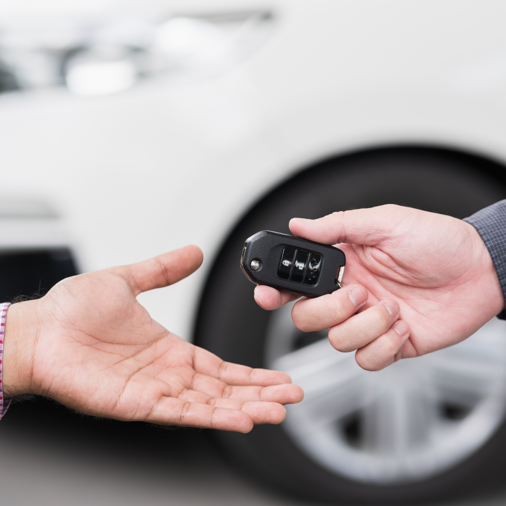 un homme donne des clés de voiture à une femme