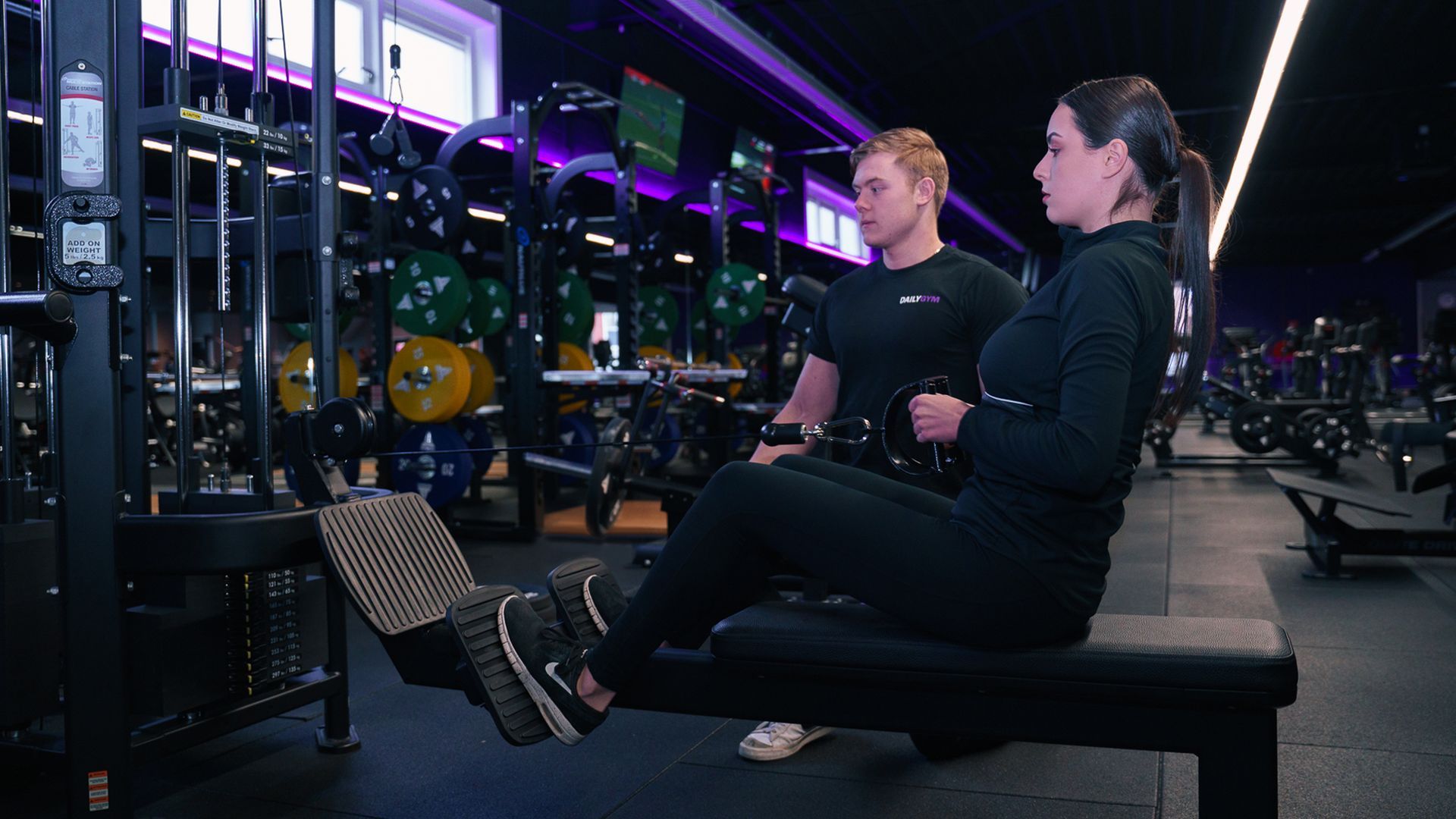 Een man en een vrouw zitten op een bankje in een gymzaal.