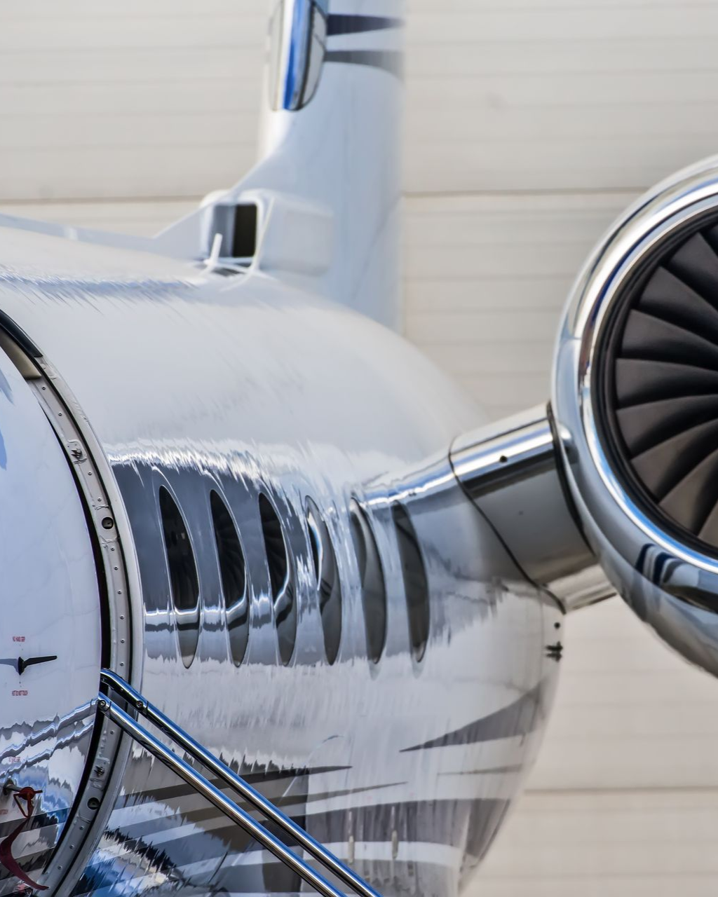Silver private jet engine and fuselage detail.
