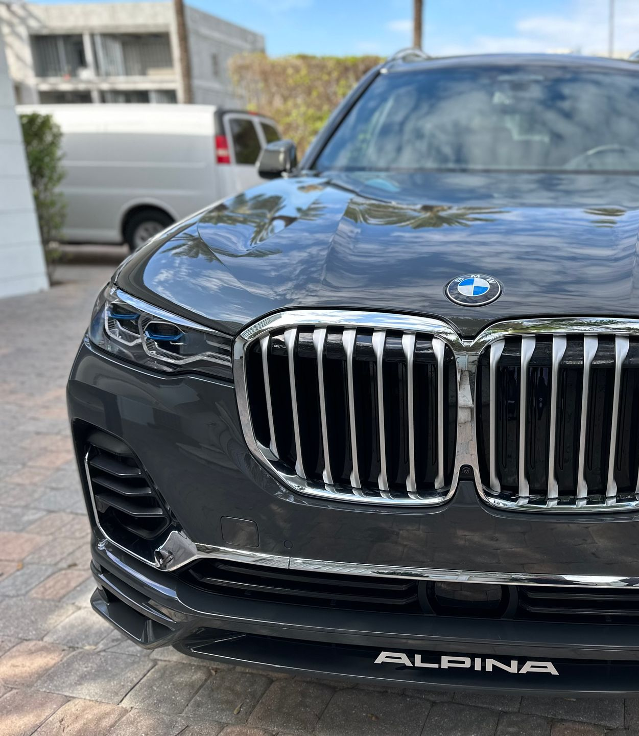Front view of a dark gray BMW Alpina SUV with a large chrome grille.
