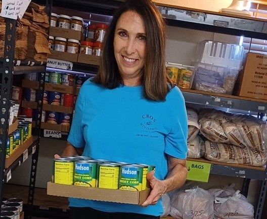 A CROS Volunteer preparing a bag of food to distribute at one of CROS' food pantries.