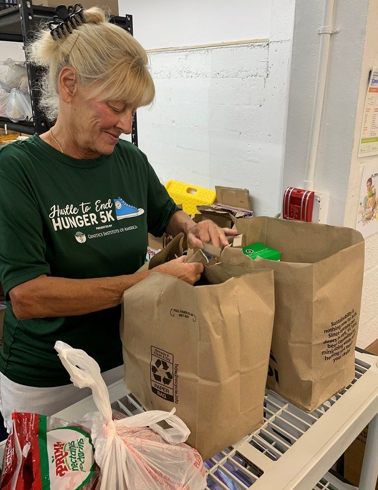 Volunteer handing out bags at a CROS food pantry.