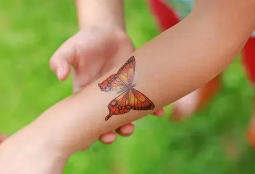 A person has a butterfly tattoo on their arm.