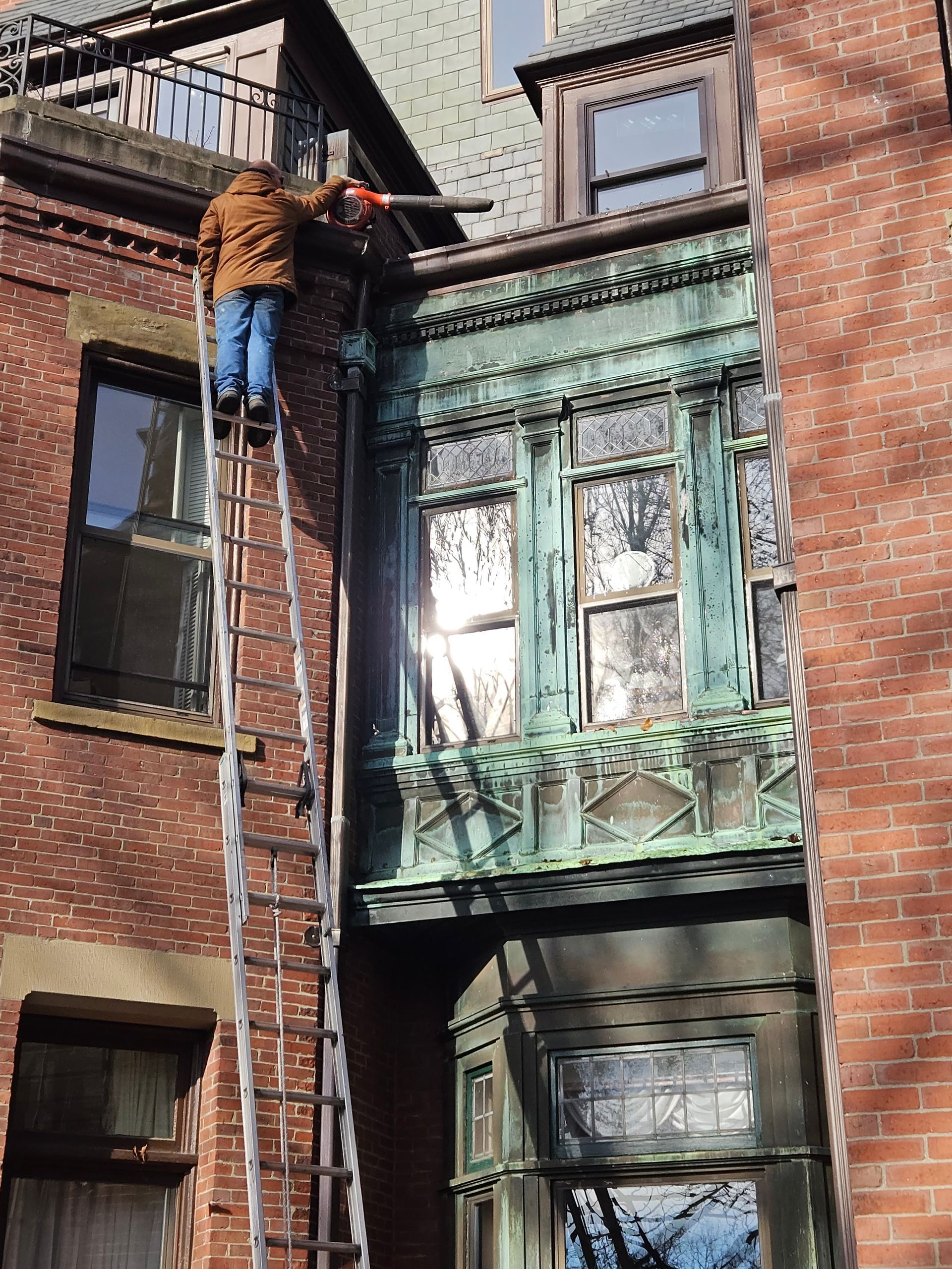 Technicians installing 6-inch K-style seamless gutters on commercial roof