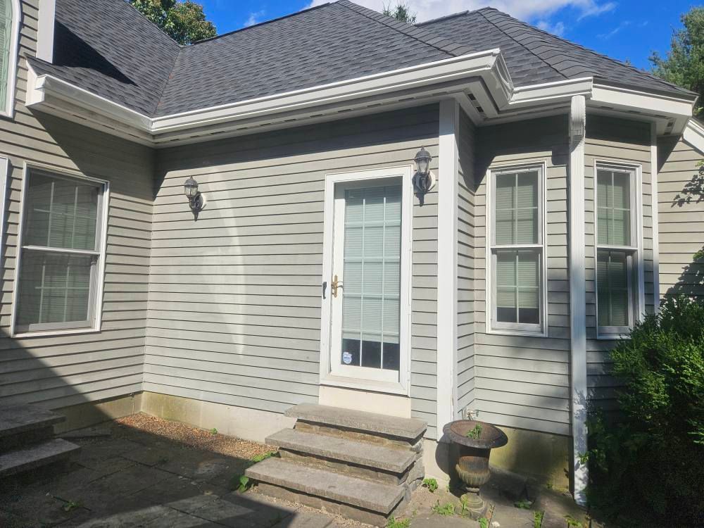 White K Style Gutters and Downspouts on a House with Light Grey Siding