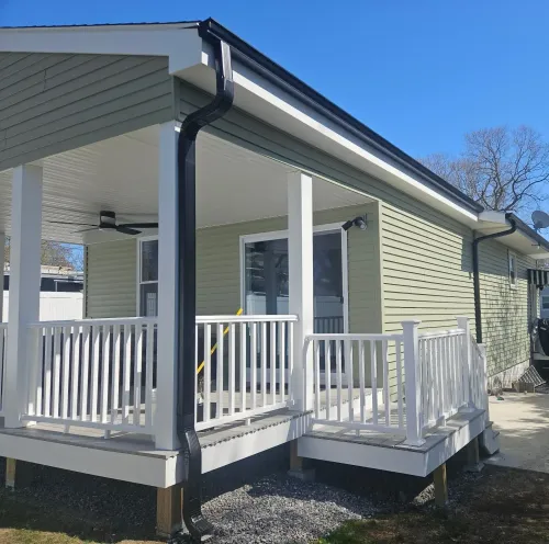 New England Gutter Systems crew installing 5-inch K-style seamless gutters on two-story NH home