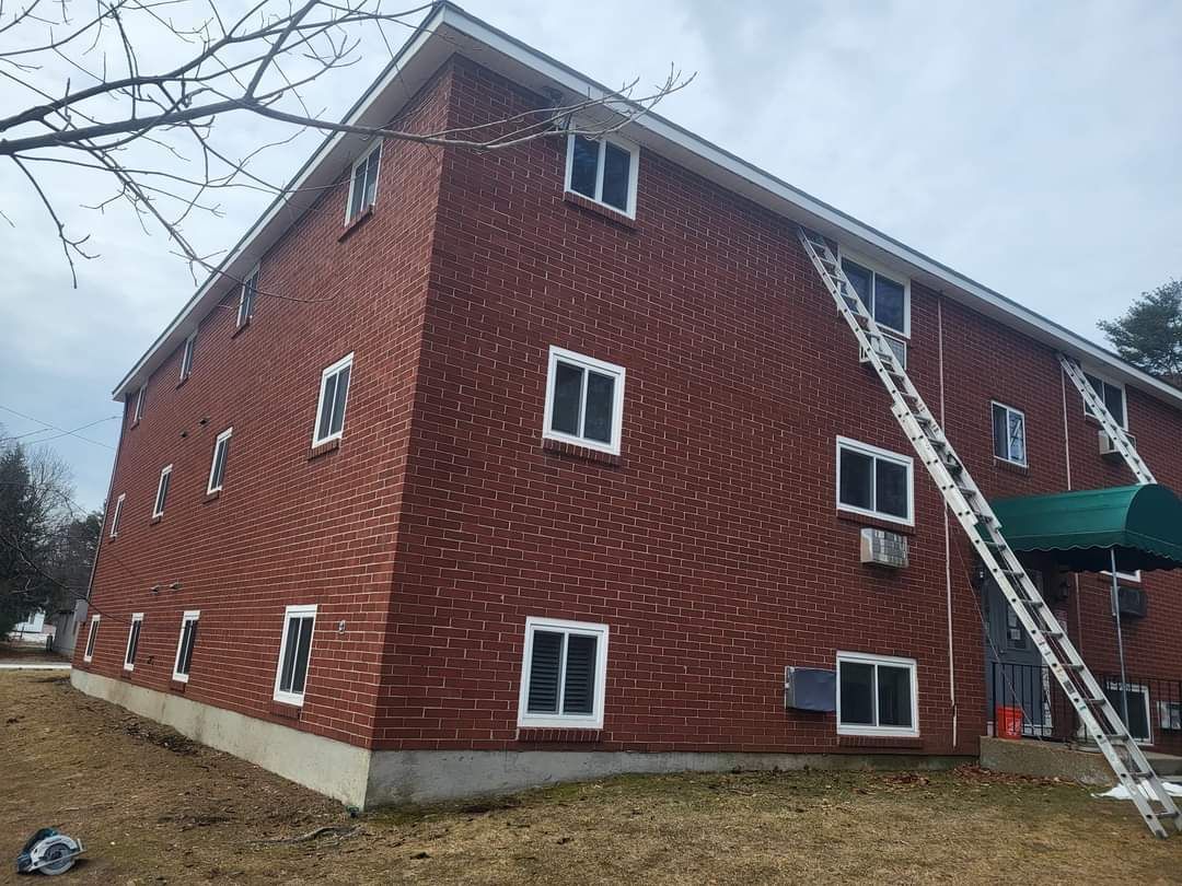 Brick apartment building with two ladders leaning against the side.