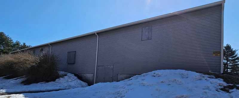 A large house with a lot of snow on the ground in front of it.