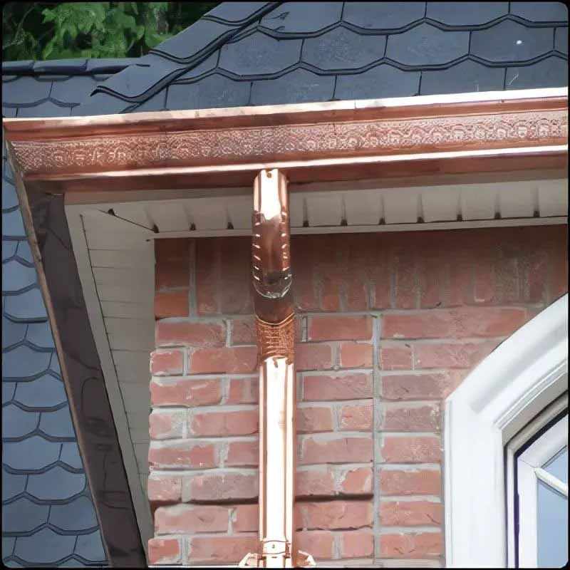 A copper gutter on the side of a brick building