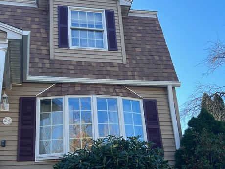 A house with a large bay window and purple shutters
