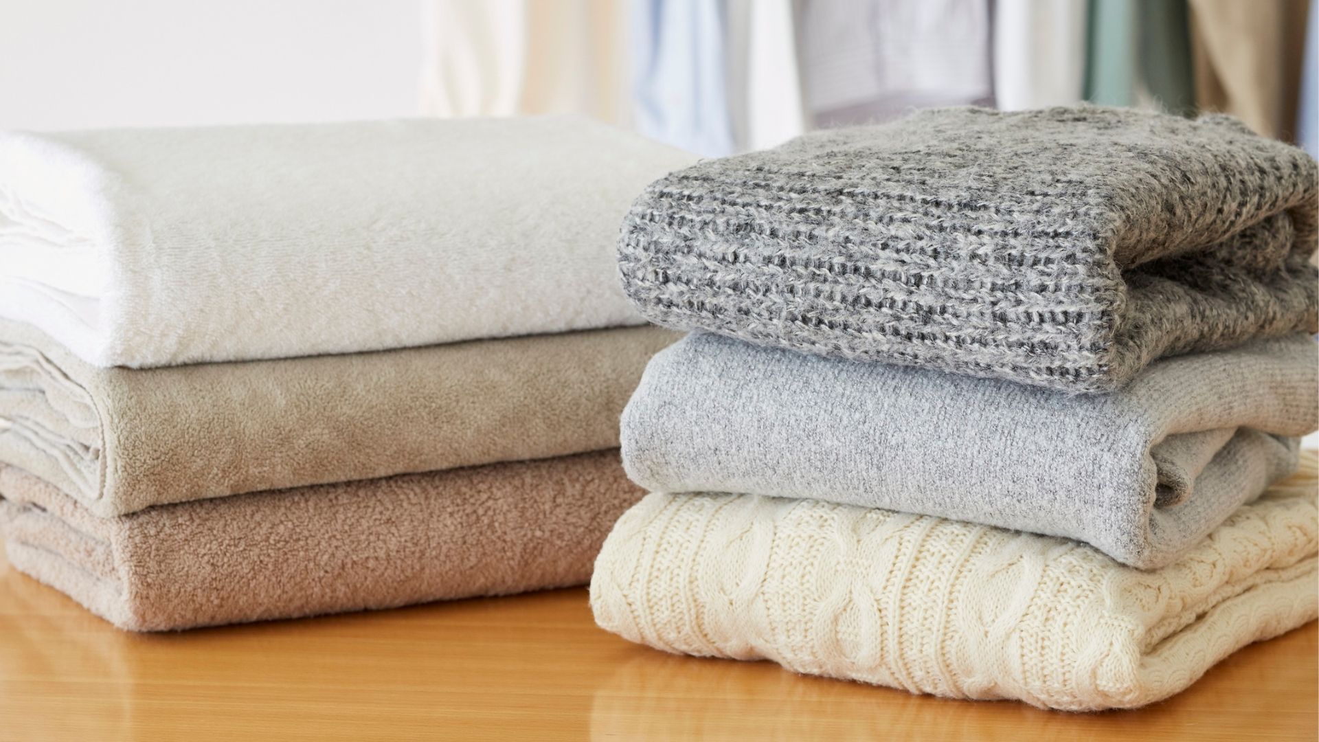 Stacks of folded towels in various neutral colors on a table.