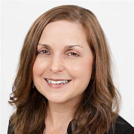 Woman with brown hair smiling, wearing a black top, against a white background.