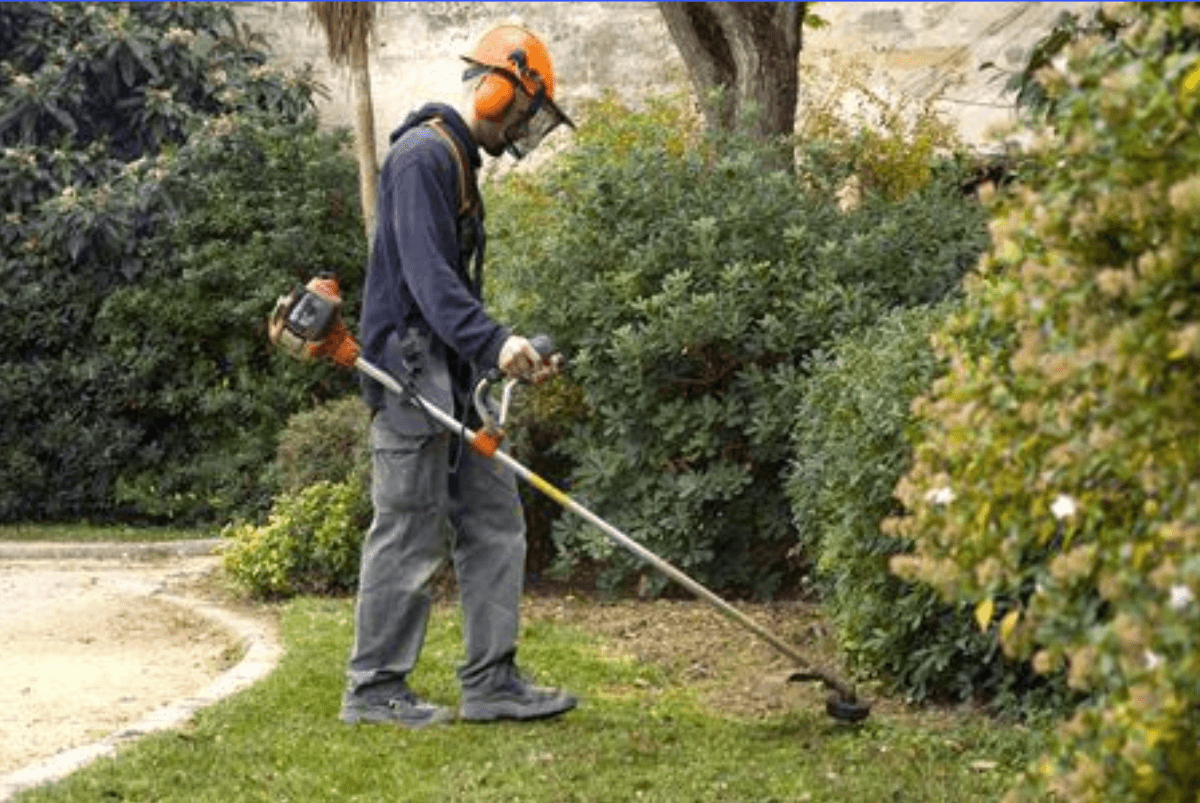 Un homme utilise une débroussailleuse