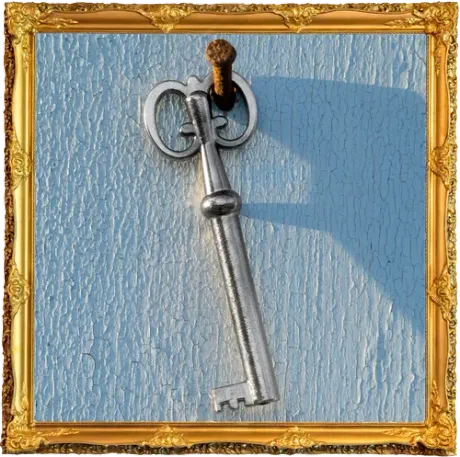 Silver key hanging on a nail against a textured, light blue surface, framed in gold.