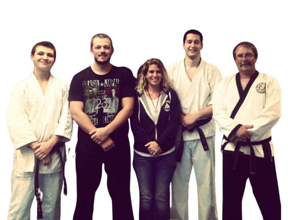A group of people are posing for a picture and one of them is wearing a shirt that says karate