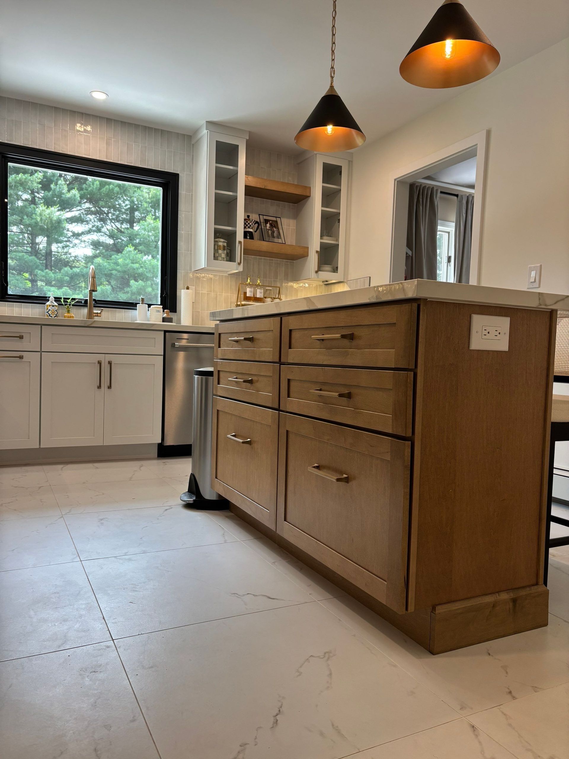 Kitchen with wood island, white cabinets, stainless steel appliances, and pendant lights.