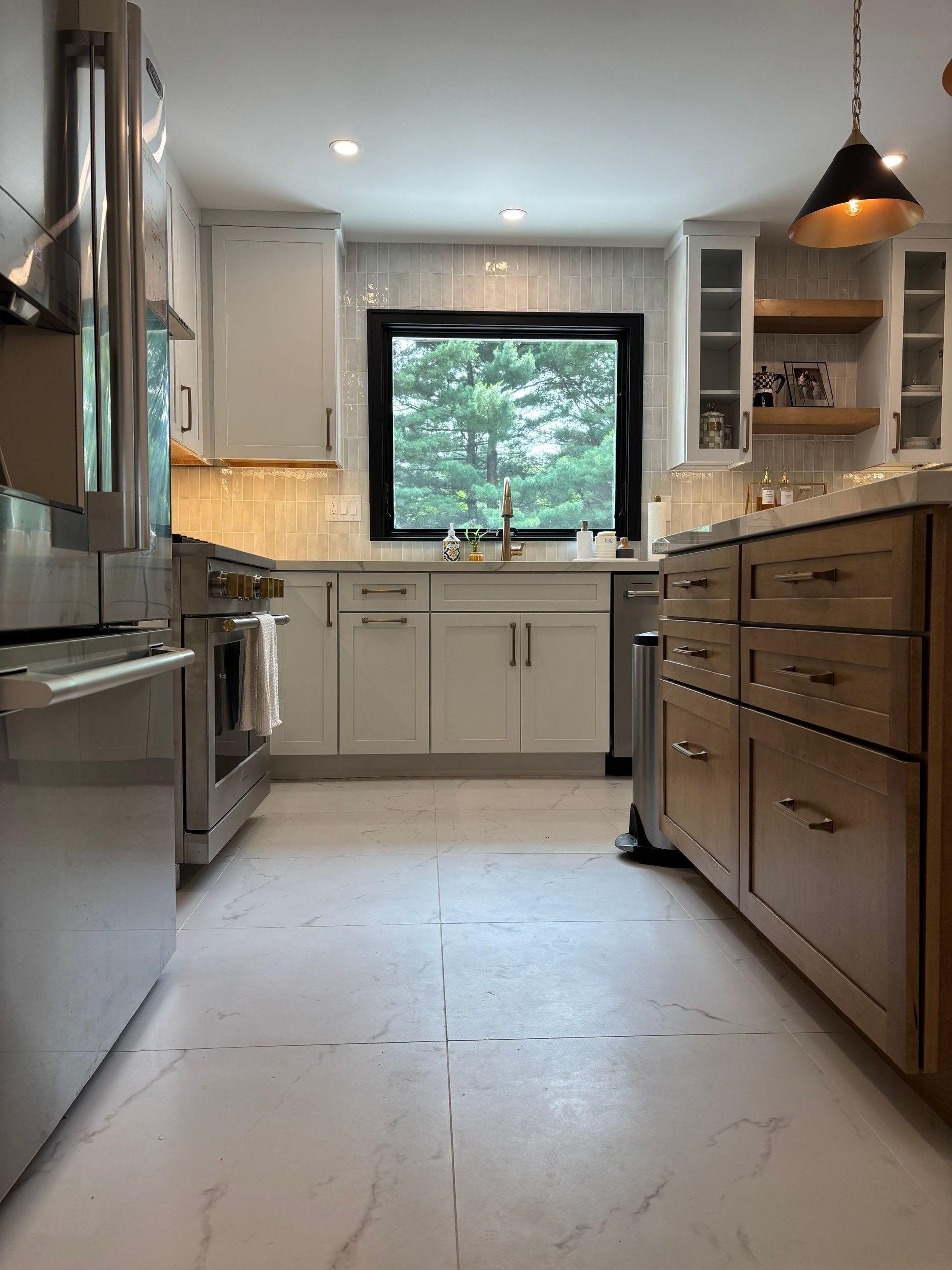 Modern kitchen with white cabinets, stainless steel appliances, and a wooden island.