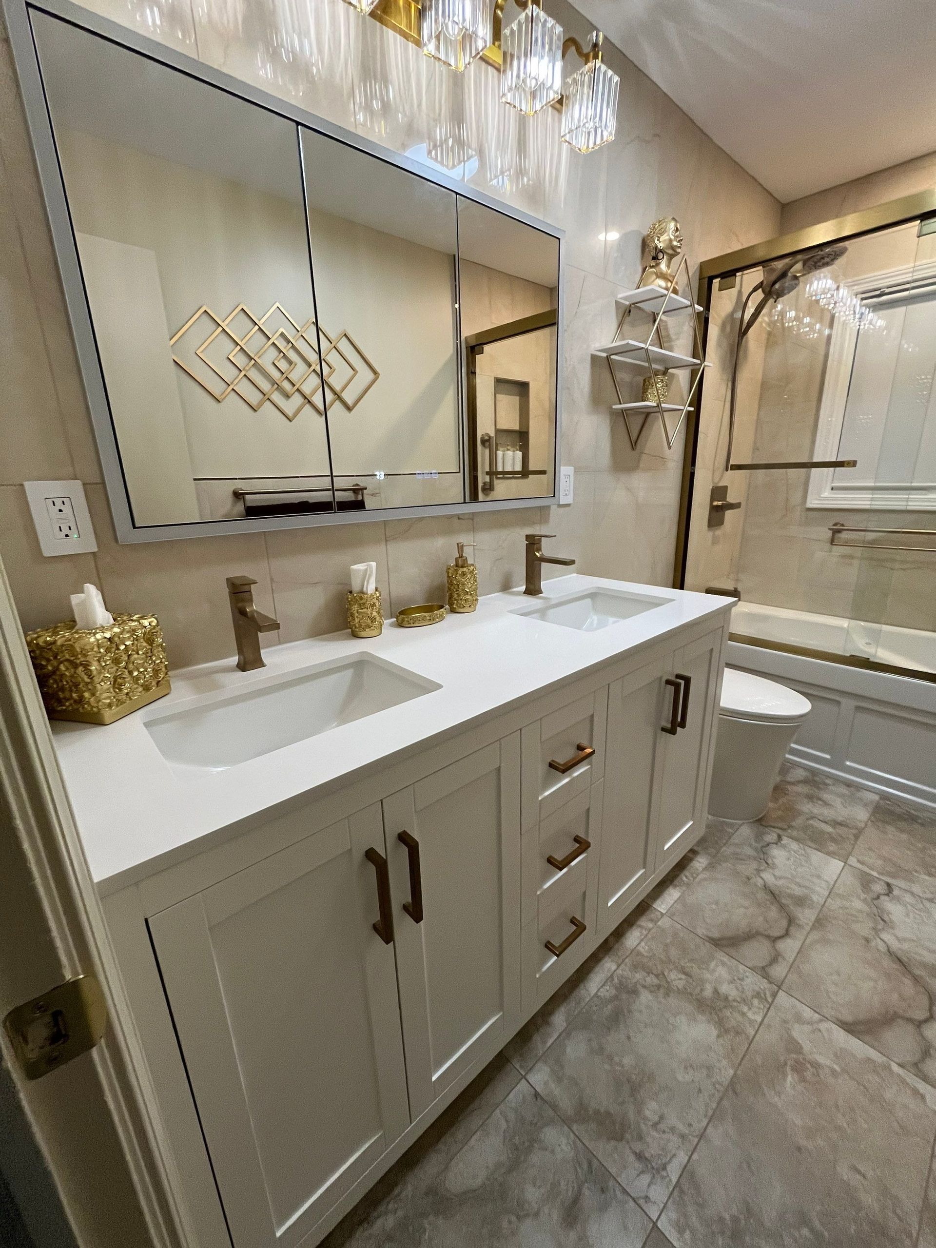 Bathroom with a white double vanity, large mirror, and gold accents.
