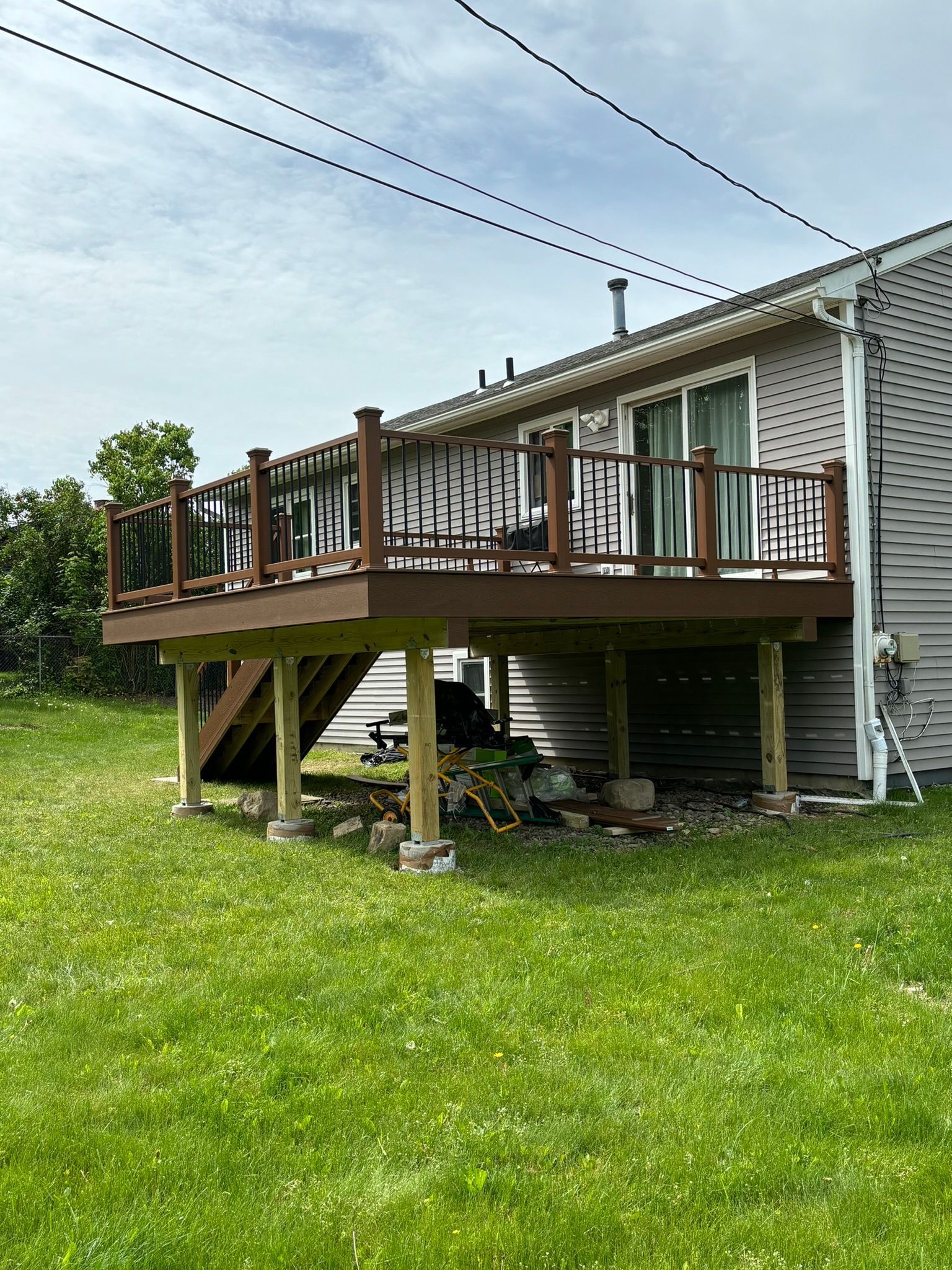 A raised wooden deck with stairs attached to a house.