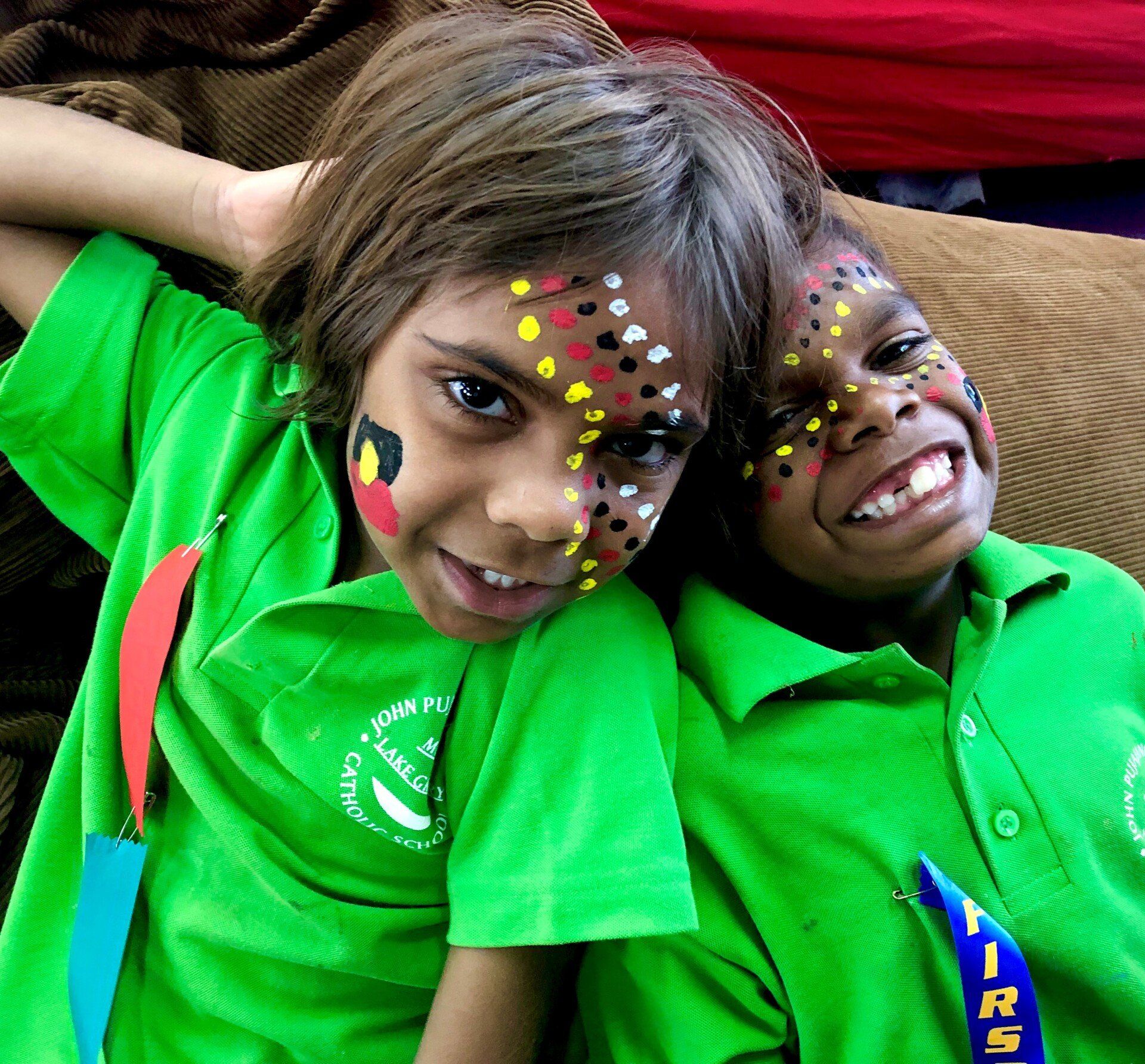 Two students smiling at camera with painted faces