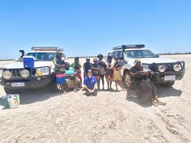 Group of students next to cars out on country