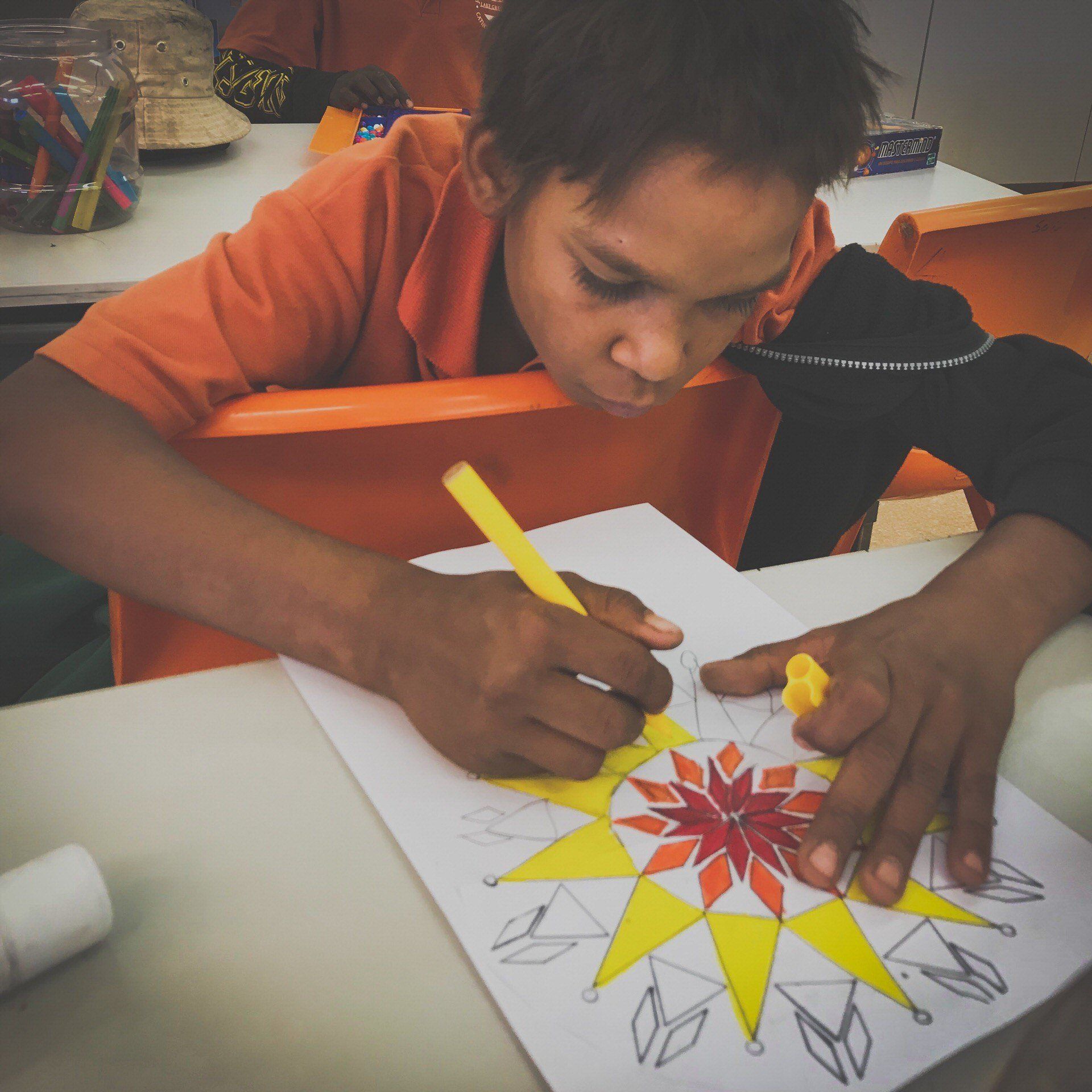 JPP School student drawing an isometric shape on white paper