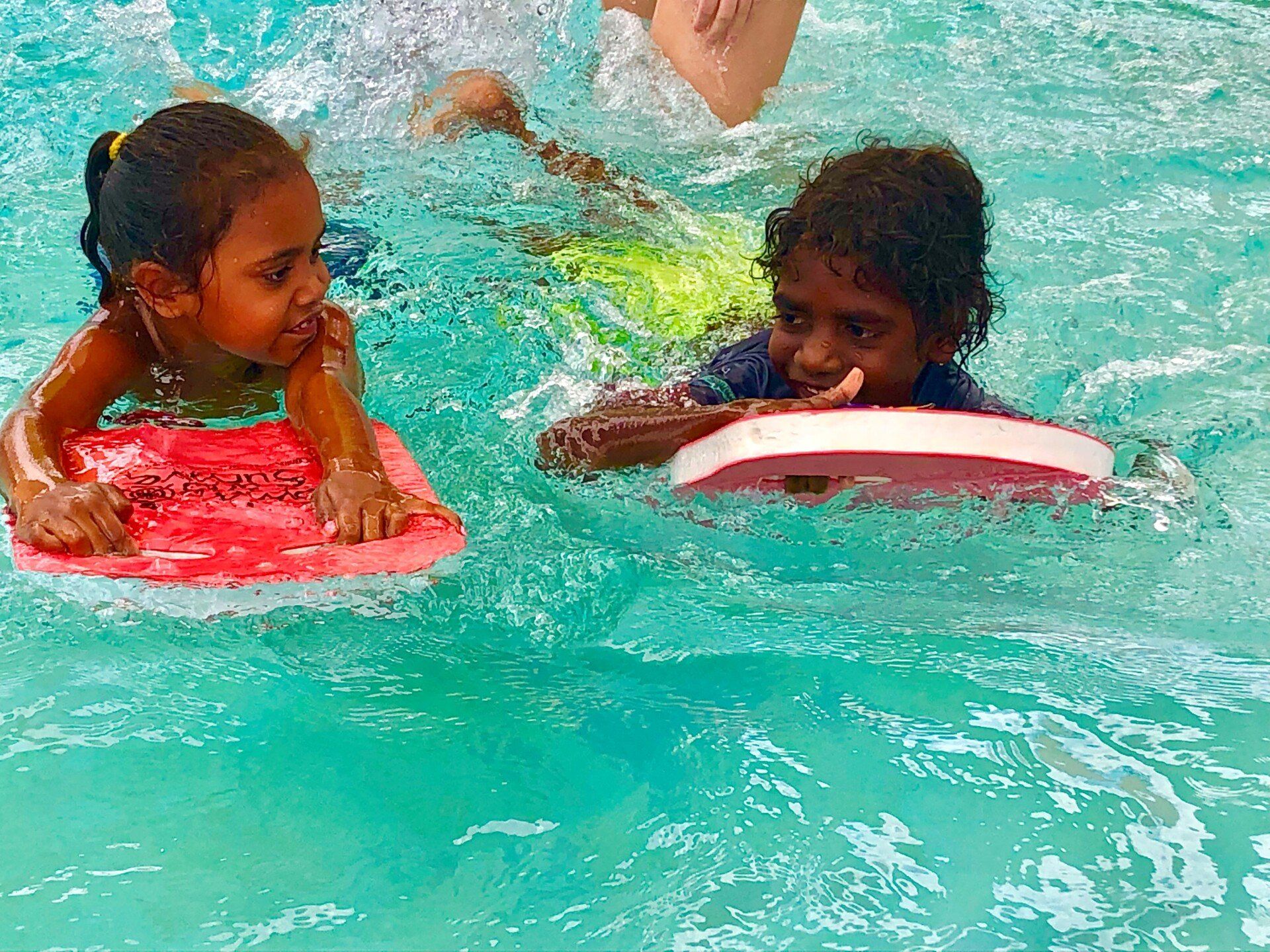 Two students swimming and smiling
