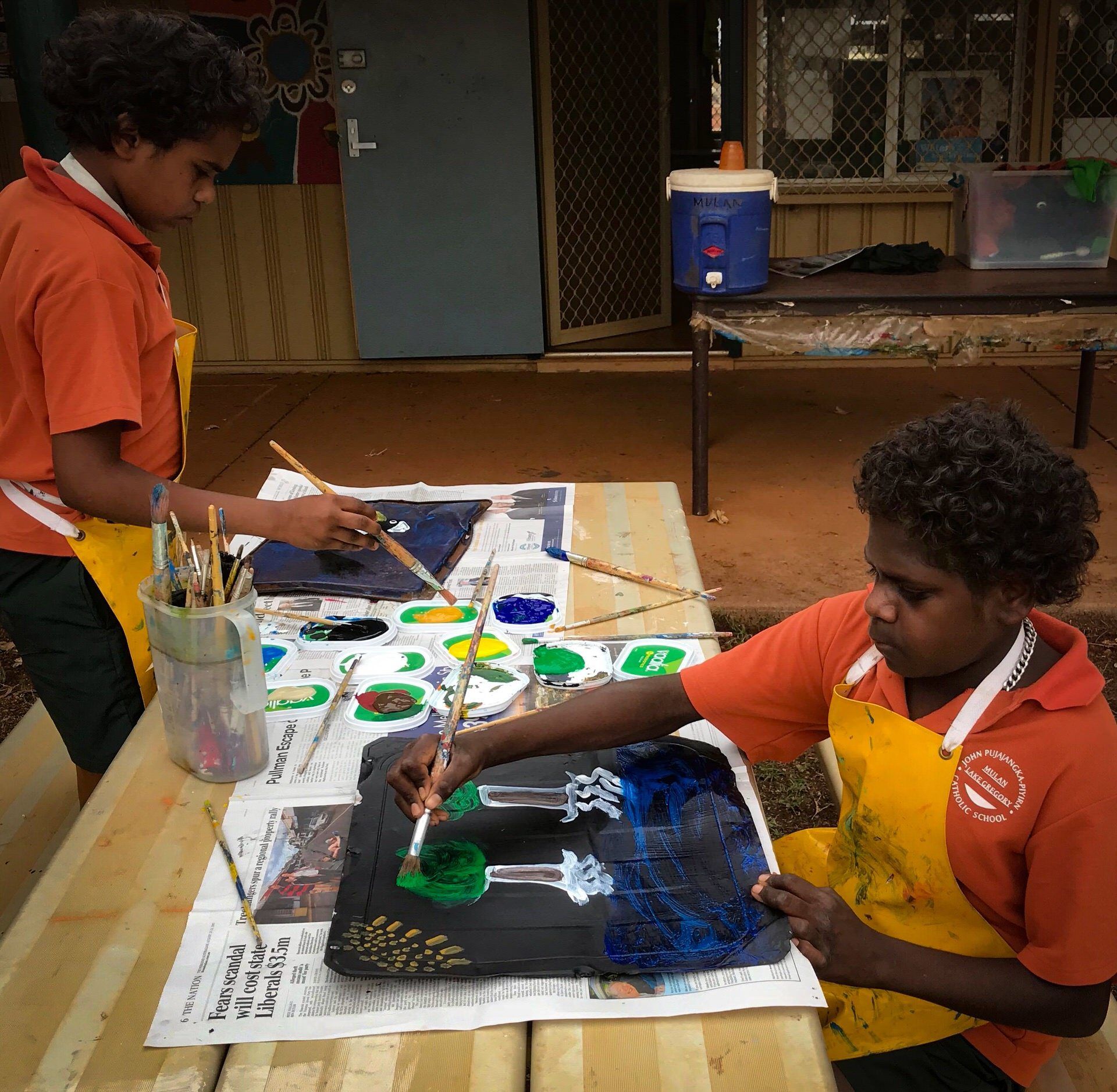 JPP School students painting at a school desk