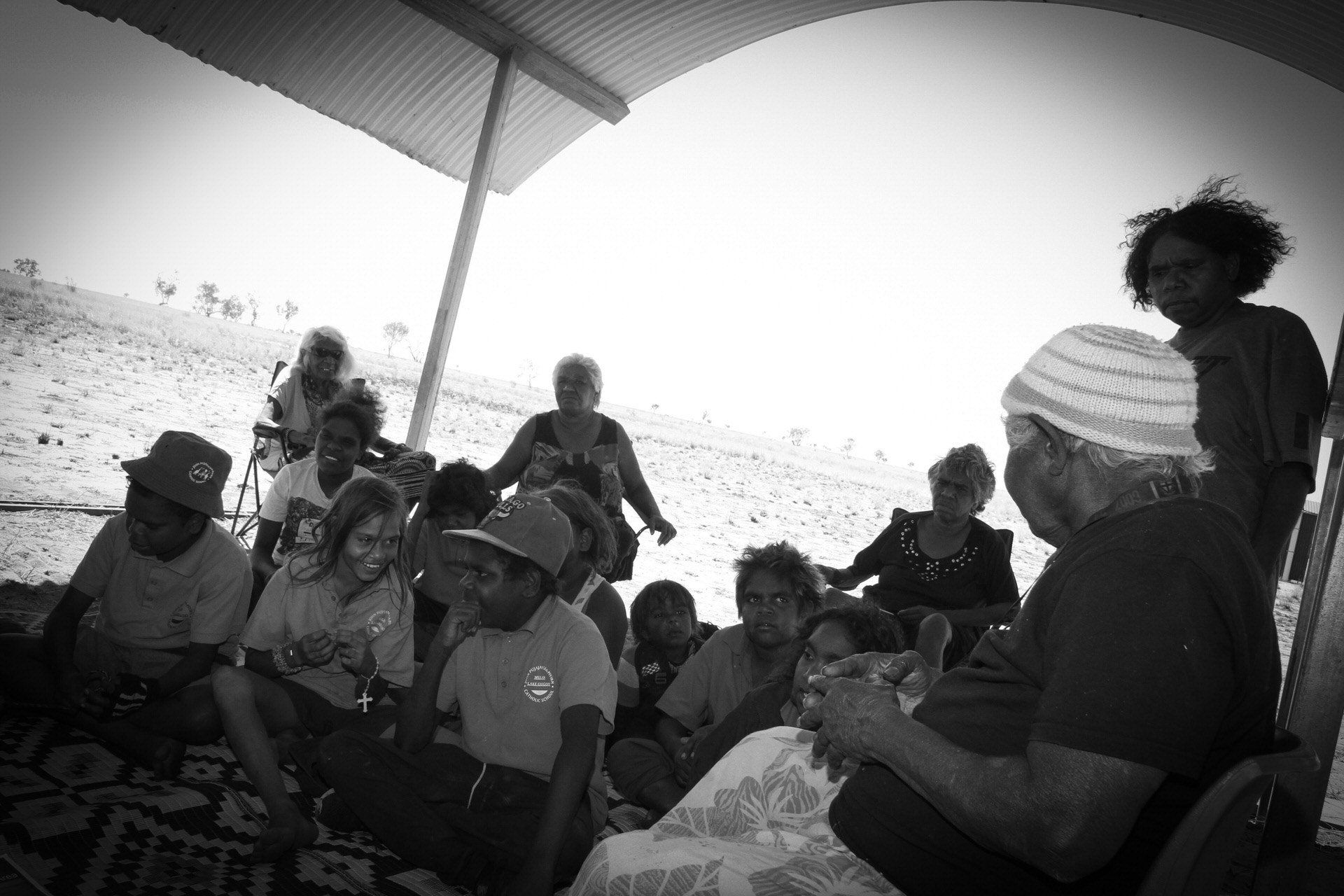 JPP School students sitting under an information shelter