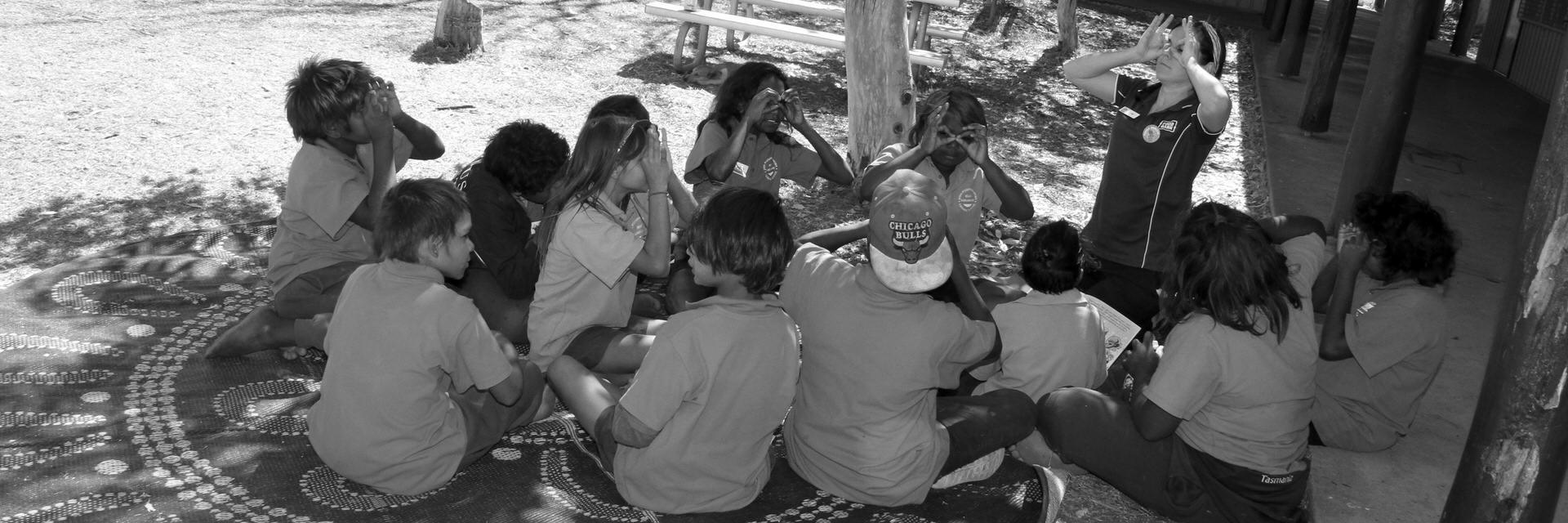 JPP School students making glasses with their fingers in the court yard at the school