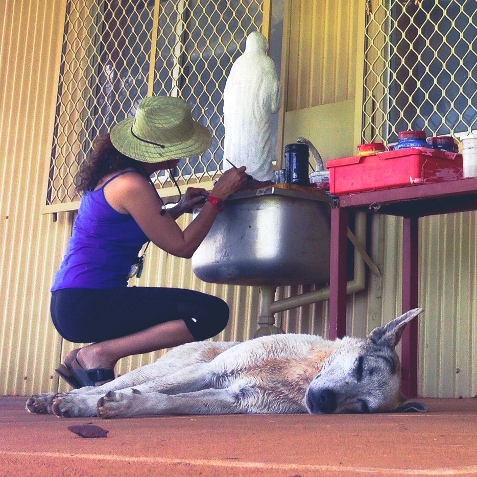 JPP School teacher painting a statue of the virgin mary while a dog sleeps