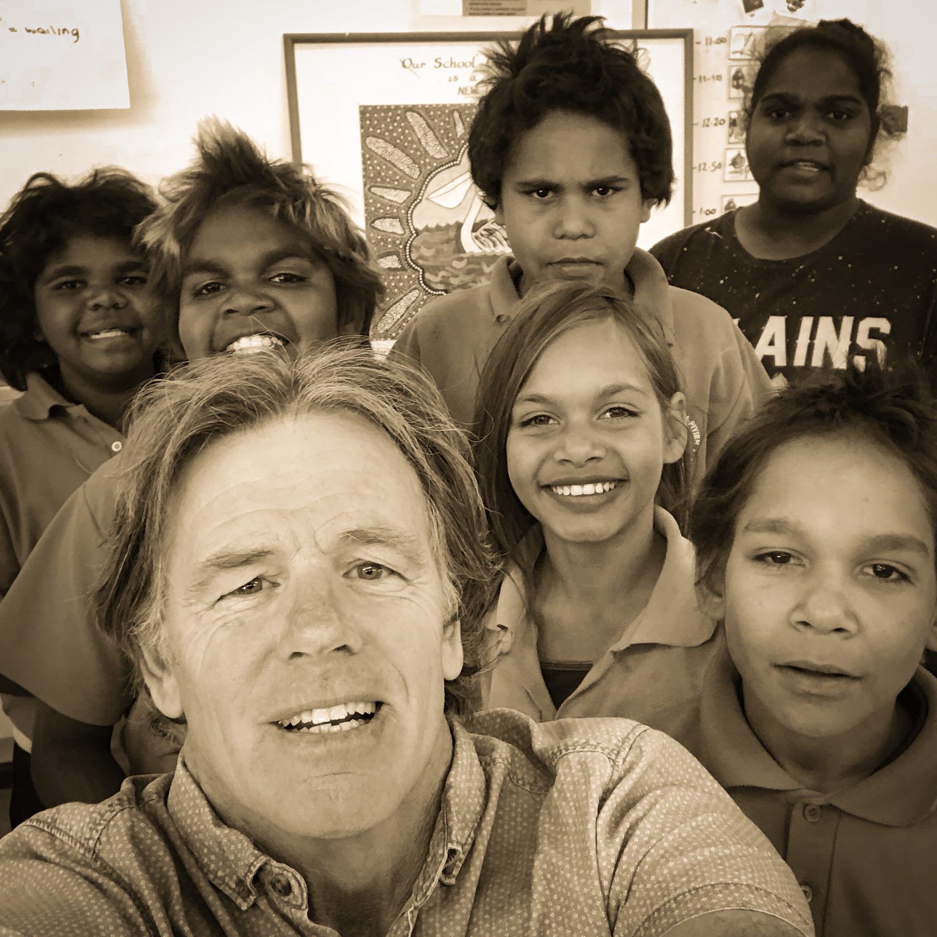 Teacher at JPP school take a selfie with six students smiling behind him