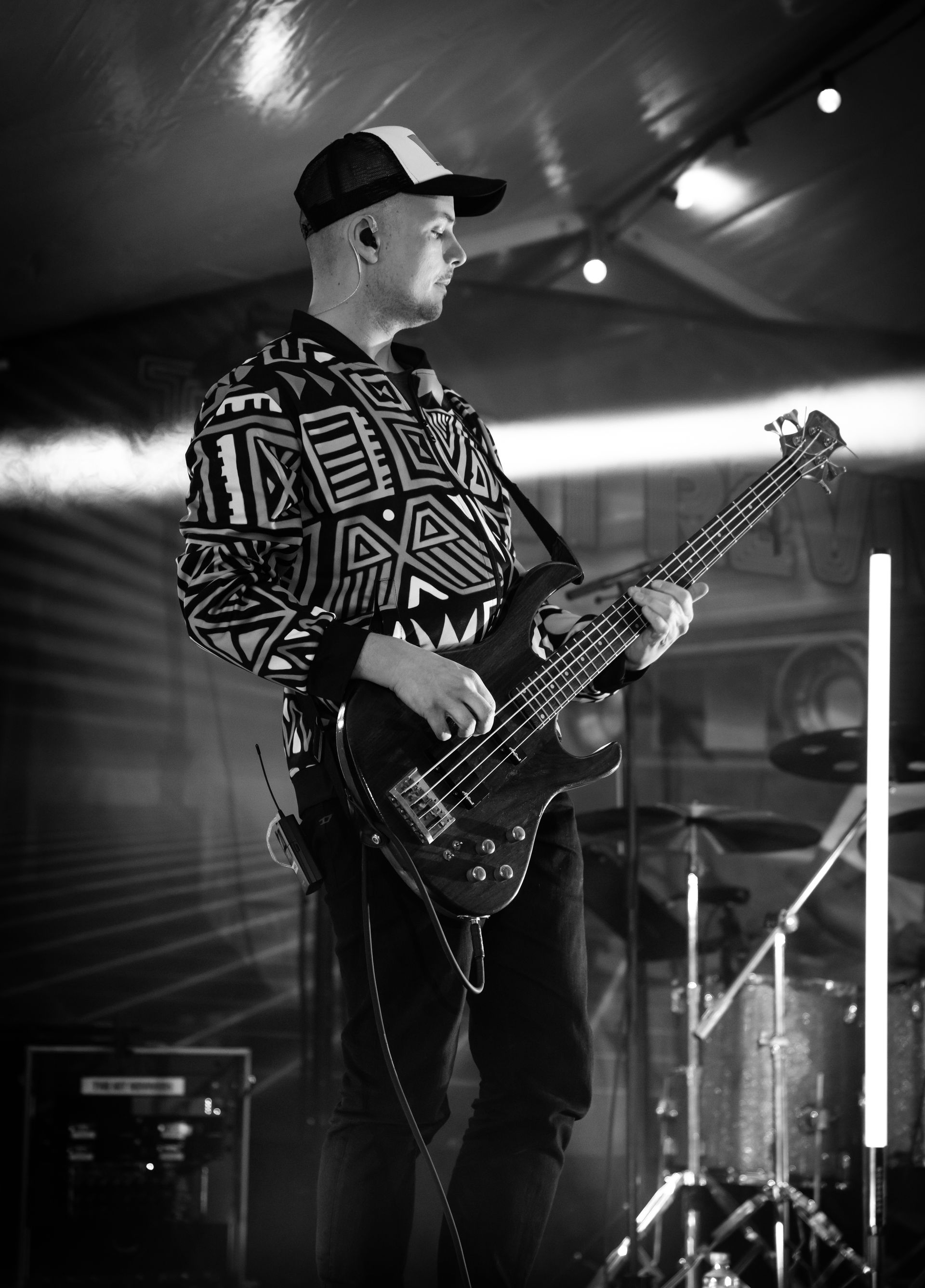 En mann spiller gitar på scenen i et svart-hvitt-bilde.