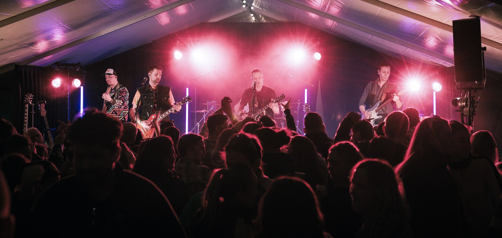 En gruppe mennesker står foran en scene på en konsert.
