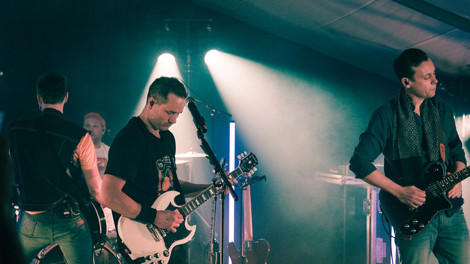 En gruppe menn spiller gitar på en scene.