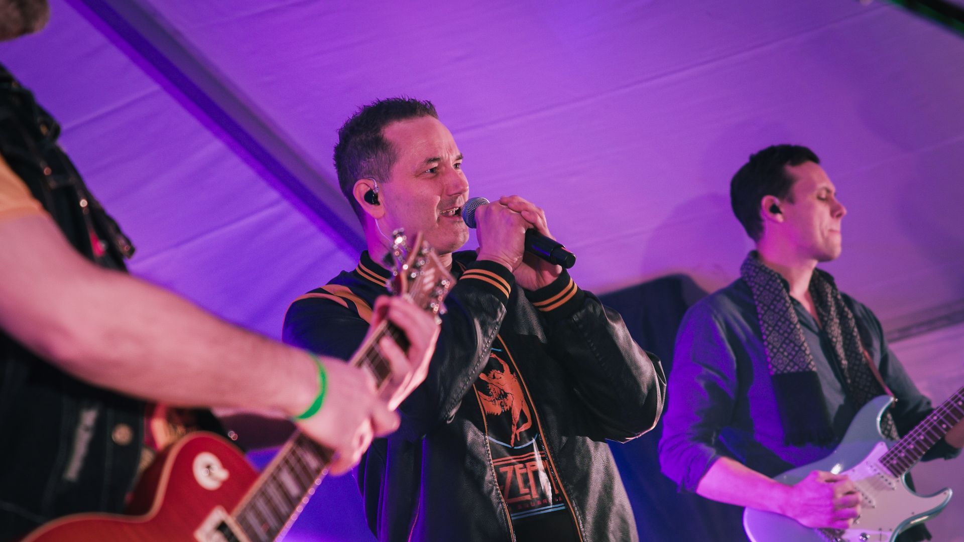 En mann synger i en mikrofon mens en annen mann spiller gitar.