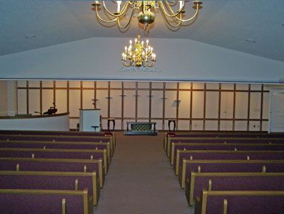 A church with rows of wooden benches and a podium
